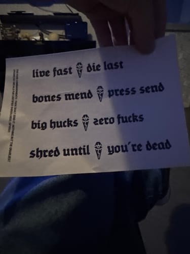 Customer's Lucky Dip sticker sheet with black text designs featuring bold phrases and small tombstone icons.