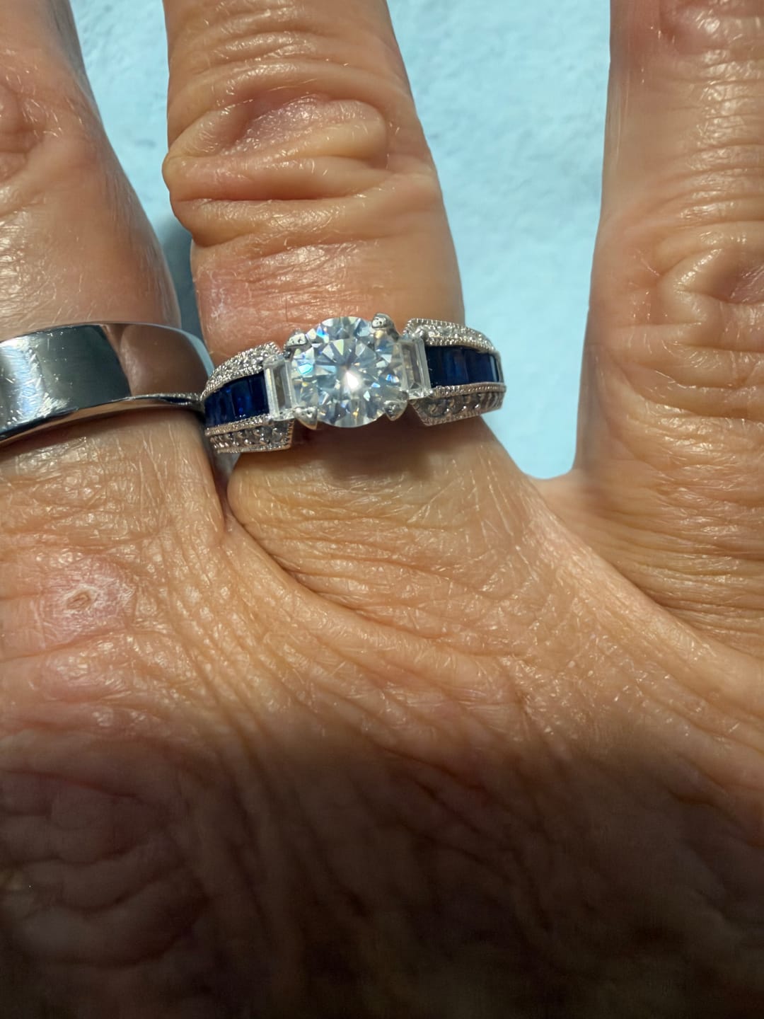 Customer photo review of Round Moissanite And Emerald-Cut Sapphire Channel Set Milgrain Engagement Ring