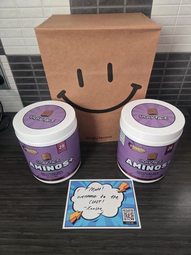 Customer's two tubs of UGLYFACE AMINOS+ in purple packaging with a branded paper bag and a handwritten welcome note.
