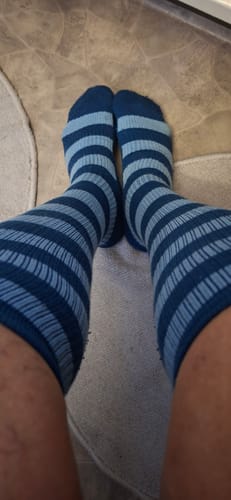 Customer's legs wearing blue and light blue striped Diasocks Stödstrumpor.