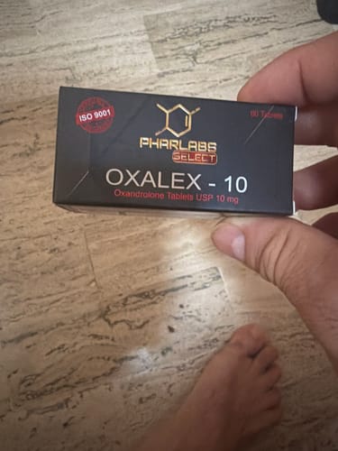 Customer's hand holding the black Oxalex-10 Phar Labs Select product box showing clear text and the ISO 9001 seal.