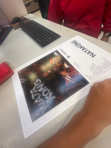 Customer's printed NATAKONG music poster lying on a white desk, ready to be framed.