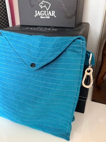 Customer's quilted headphone case made from bright blue needlecord fabric with a silver snap closure