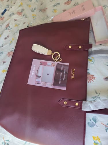 Customer's Starlight Keyring with vegan leather loop and gold-tone hardware resting on a burgundy bag.