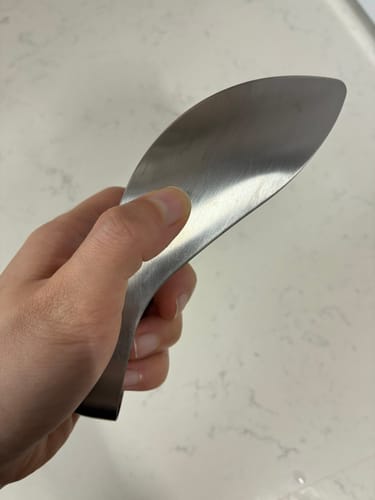 Customer's hand holding the silver stainless steel Leye finger tongs, highlighting the sharp, curved design.