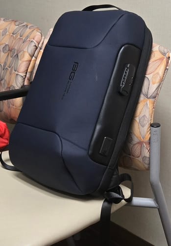 Reviewer's Sac à Dos Antivol Homme bleu foncé posé sur une chaise, montrant la serrure de sécurité intégrée.