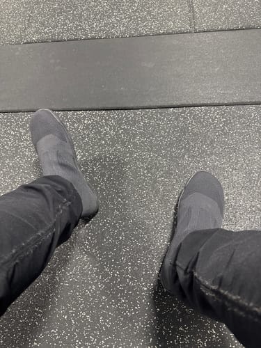 Customer's gym shoes on a black rubber gym floor.