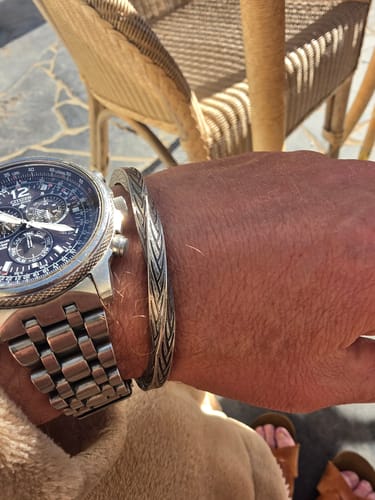 Reviewer's silver Woven Covenant bracelet worn on the wrist next to a metal watch.