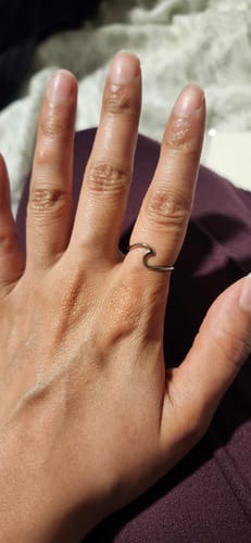 Customer's silver Imari Silver Wave ring, featuring a thin, minimalist wave design worn on a finger.