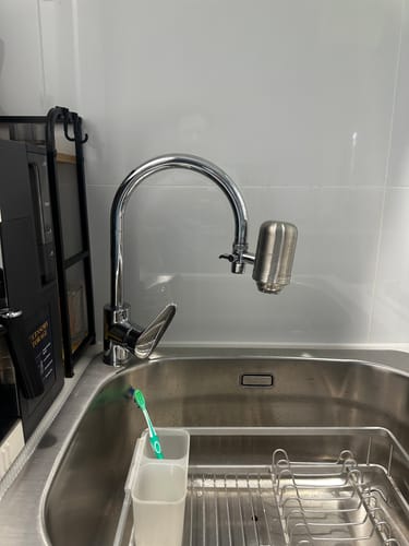 Customer's BlissfulHome Advanced 5-Stage Kitchen Tap Filter installed on a kitchen faucet above a stainless steel sink.