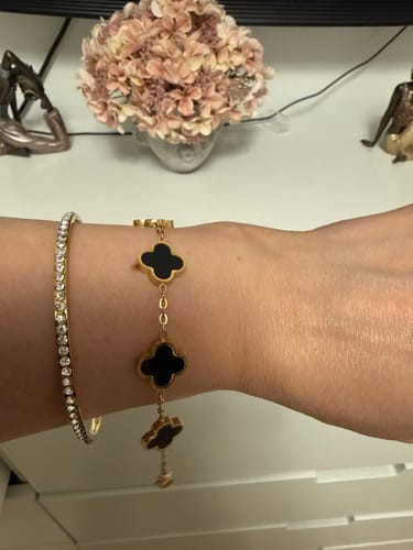 Customer's wrist wearing a gold Black Clover Bracelet alongside a delicate crystal bangle.