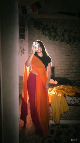 Customer's Date Night saree in orange and pink, being worn in a mirror selfie.