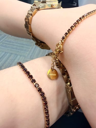 Customer's gold Ava Gold Burgundy watch with a matching dark red beaded bracelet on wrist.