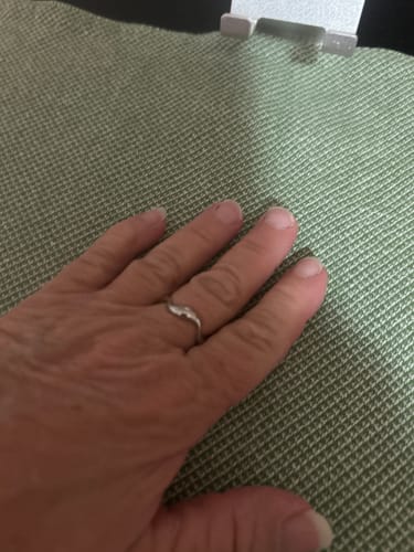 Customer's hand wearing the minimalist Silver Wave Ring, featuring a slender, textured metal design.