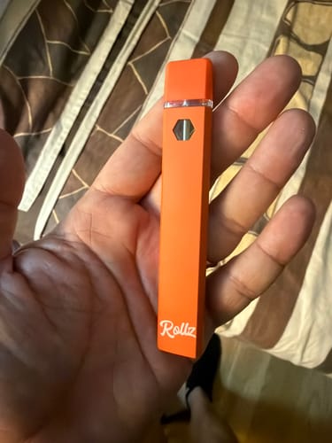 Customer's orange Rollz THC-A vape device held in a hand
