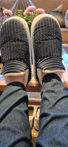 Customer's HappyCozy donkerblauwe sloffen met voering, gedragen aan de voeten in een woonkamer.