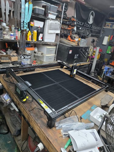 Customer's AtomStack A70 Max laser cutter assembled and sitting on a wooden workbench in a workshop.