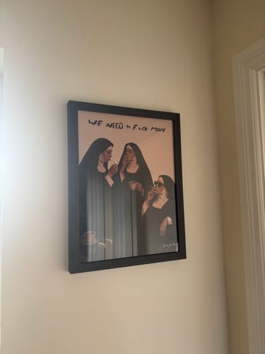 Customer's framed Out Of Office art print of three nuns hanging on a neutral-toned wall.