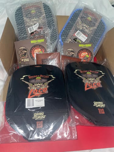 Customer's box containing two packaged Loco paddle covers and two visible Loco paddle covers in black plastic wraps.