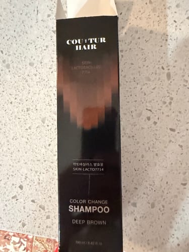 Reviewer's GDS Hair Dye Shampoo packaging, deep brown color variety, standing on a speckled countertop.