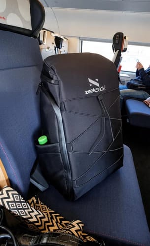 Kundens svarta The Organizer 30L ryggsäck placerad på ett tågsäte.