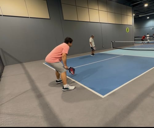 Reviewer wearing CUURT Muuv court shoes while playing a match on an indoor court.