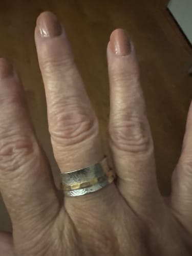 Customer's Two Tone Silver Spinner Ring worn on a finger, showing textured silver and gold-toned bands.