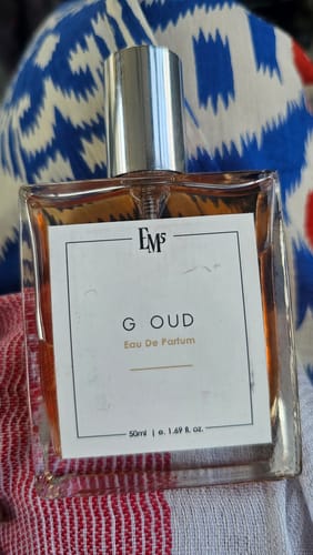 Customer's G Oud Eau De Parfum bottle with clear liquid and white label on a patterned background.