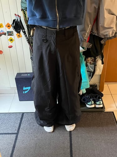 Customer's black Men's Lightweight Inner Leg Vents Baggy Snow Pants worn with a blue hoodie, showing a wide, loose fit.