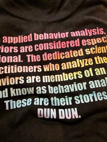 Customer's DTF Super Soft Powder printed design on black fabric with rainbow gradient text.
