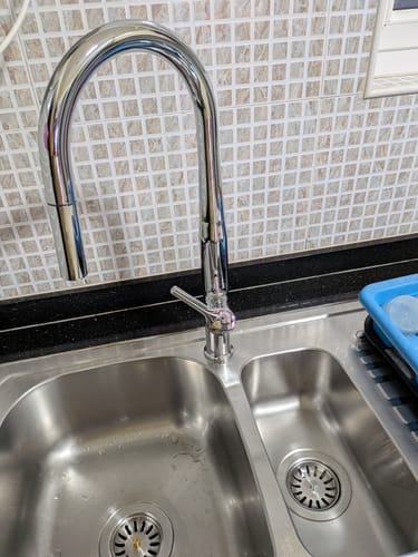 Customer's Limescale Remover on a clean, shiny stainless steel kitchen sink and chrome faucet.