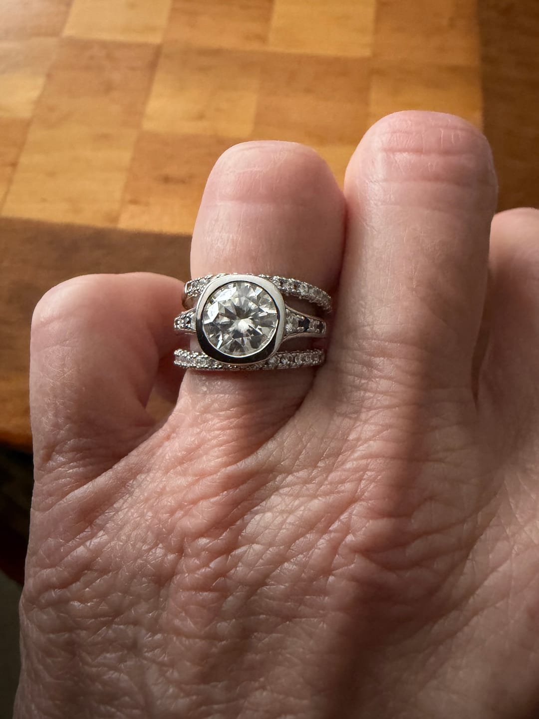 Customer photo review of Hidden Halo Bezel Round Moissanite and Blue Sapphires Engagement Ring