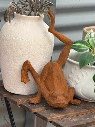 Customer's Major Ribbit French Provincial Frog Statue, a rusty iron frog mid-handstand on a wooden slatted surface.
