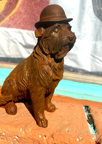 Customer's Mr Capone French Provincial Terrier Statue in a rusty, wiry-textured cast iron, set on a ledge.
