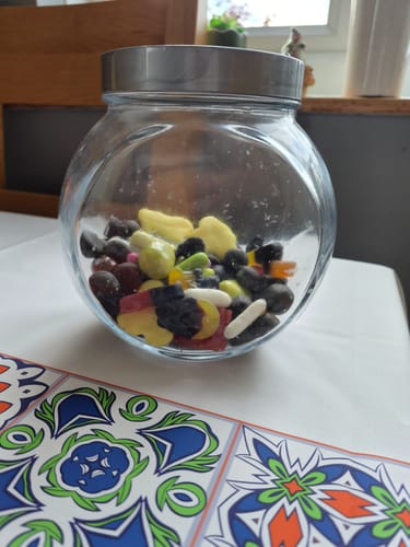 Customer's glass jar filled with a mixed assortment of Discovery Liquorice Bundle sweets on a table.