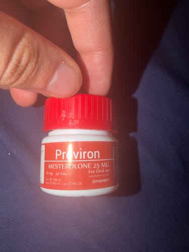 Customer's hand holding a Proviron 25mg bottle with a red cap, focusing on the product label.