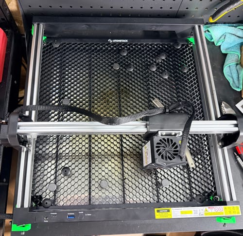 Customer's AtomStack Swift laser engraver featuring a black honeycomb base on a workshop table.