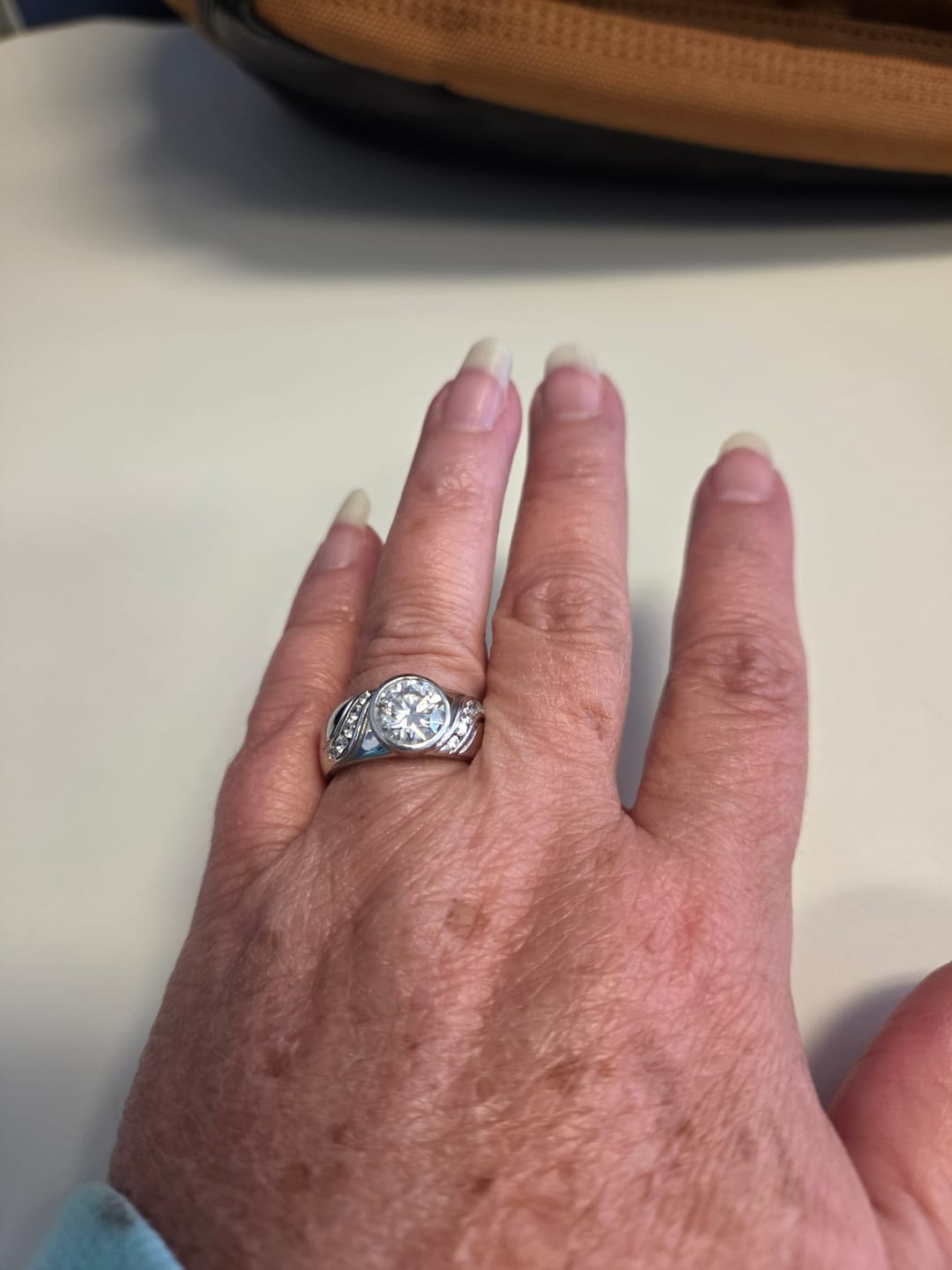 Customer photo review of Endless Flow Round Bezel Set Moissanite Wide Band Engagement Ring