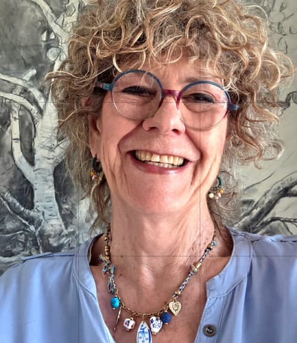 Customer's smiling person showing well-managed, curly hair after using the Kevin Murphy Smooth.Again Treatment.