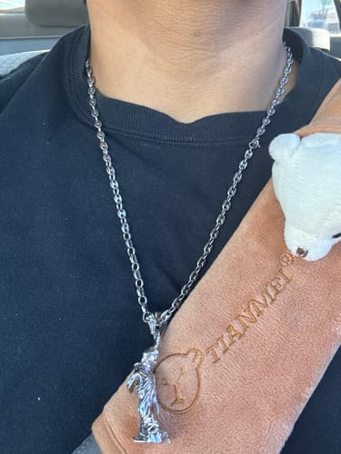 Customer's silver Infinity Chain worn around the neck with a detailed metallic pendant.