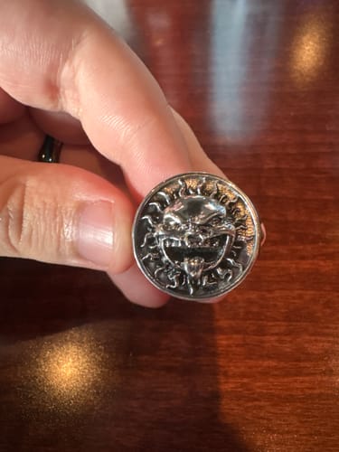 Customer's hand holding the silver UPGRADED SUNNY RING, showing the detailed sun face design with mouth open