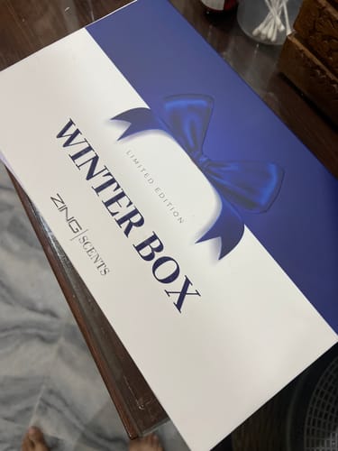 Customer's Zing Scents Winter Box, a blue and white branded gift box featuring a decorative ribbon.