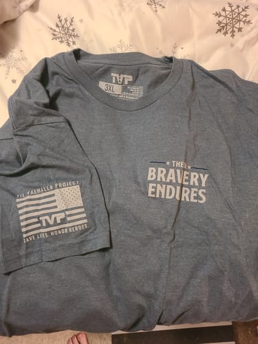 Customer's blue TVP Elite Membership shirt featuring a graphic with the text The Bravery Endures and a flag on the sleeve.