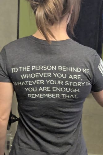 Customer's dark grey To The Person Behind Me tee, worn and showing the inspirational white printed text on the back.