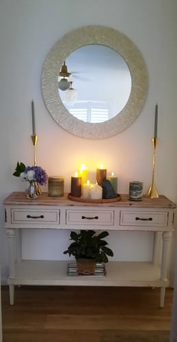 Customer's Seville French Provincial Console Table styled with a round mirror, tall gold candles, and decor.