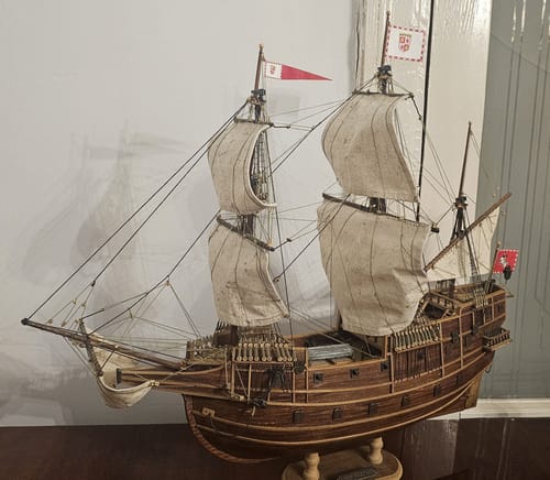 Customer's completed San Martín ship model, featuring wooden hull, white sails, and detailed rigging.