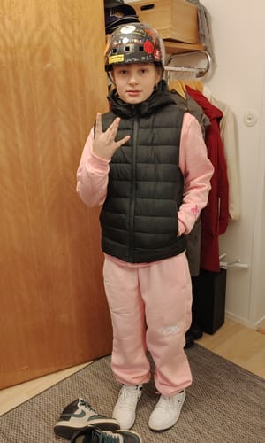 Customer's Jogging Protect Rose pink pants worn with a black vest and white sneakers.
