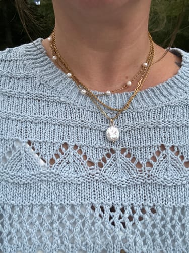 Customer's Coco Rope Necklace layered with a pearl chain on a person wearing a light blue knit sweater.