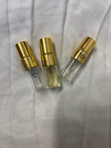 Customer's Kiage Tester Set containing three small glass perfume samples with gold lids on a white fabric surface.