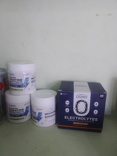 Customer's Wellcore Creatine Monohydrate jars alongside a box of Osmo Electrolytes on a plain surface.